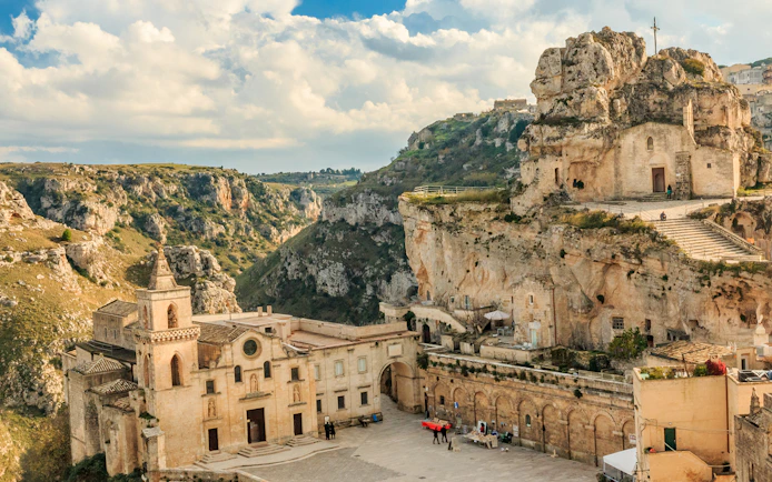 Matera's ancient rock church and historic buildings in a scenic landscape.