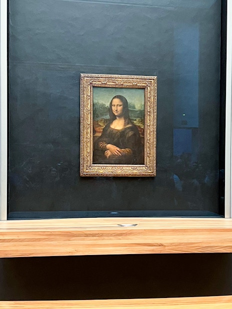 Mona Lisa displayed at the Louvre Museum in Paris during a guided tour.