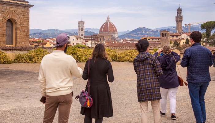 Visitors enjoying a view of Florence's skyline from Boboli Gardens, featuring the Duomo and Palazzo Vecchio.