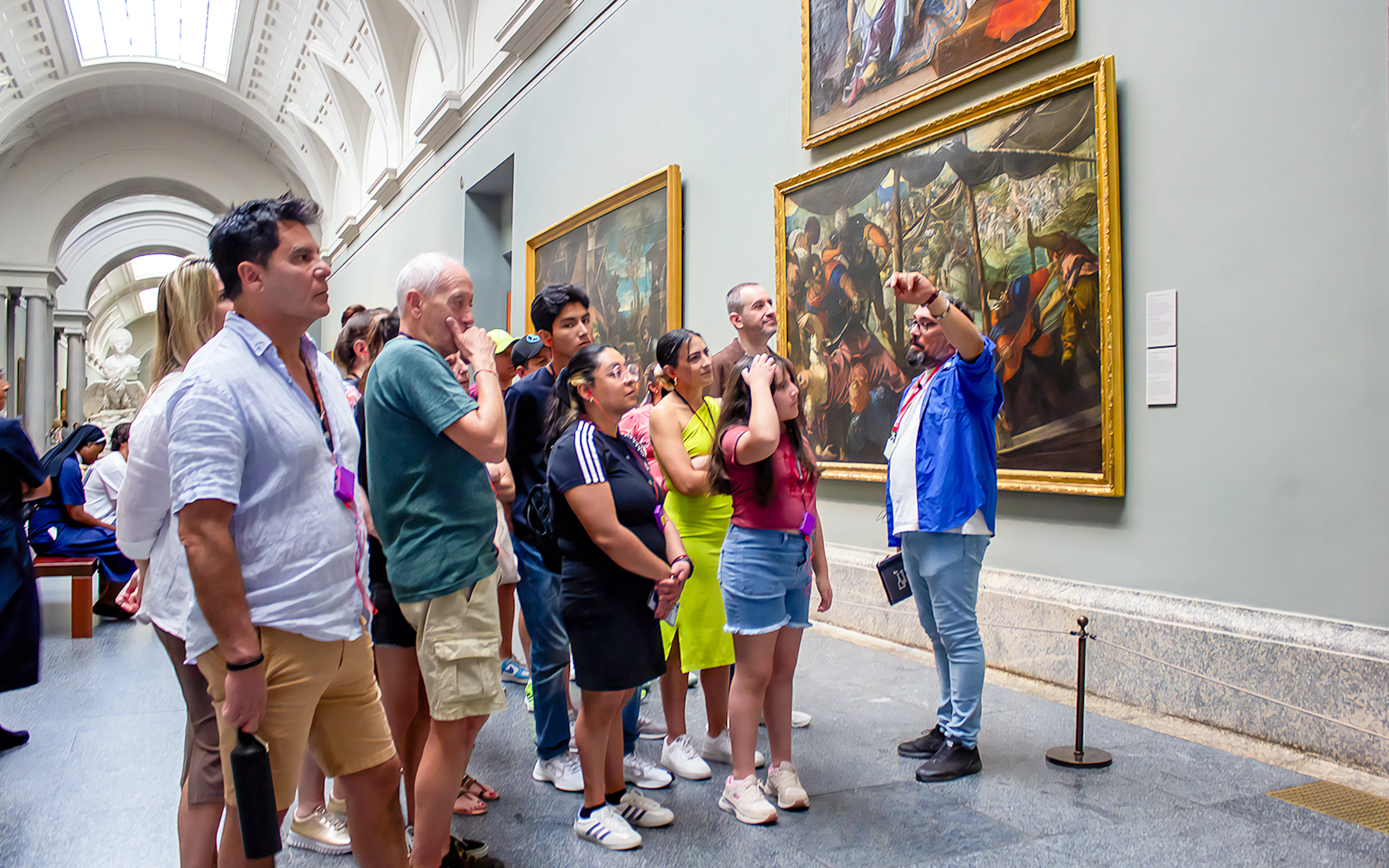 Visitors on a guided tour viewing paintings at Prado Museum, Madrid.