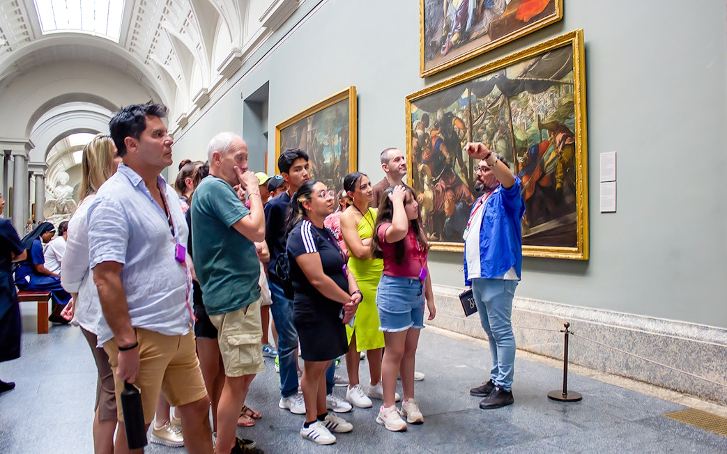 Visitors on a guided tour viewing paintings at Prado Museum, Madrid.