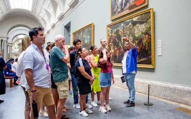 Visitors on a guided tour viewing paintings at Prado Museum, Madrid.