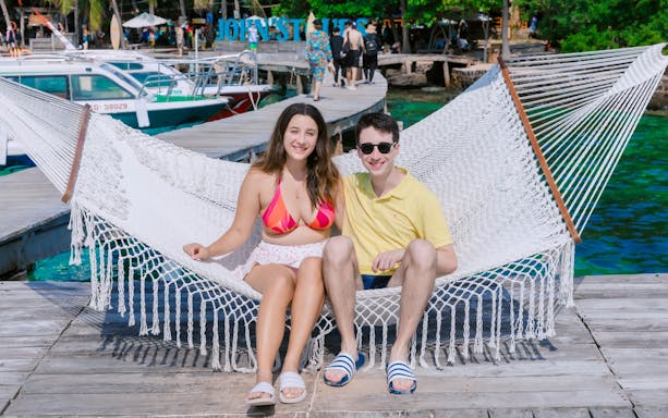 Tourists relaxing on a hammock at May Rut Trong Island pier.