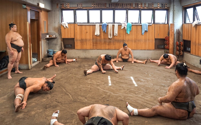 Sumo wrestlers stretching during morning practice at Ryogoku, Tokyo.