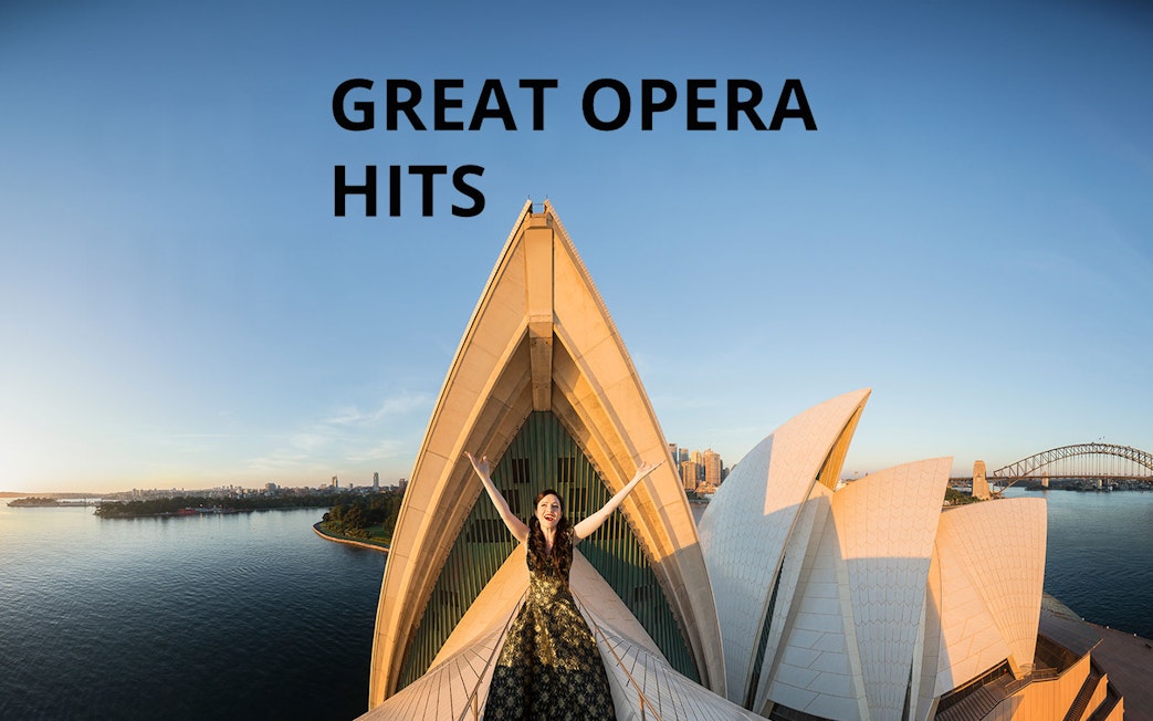 Opera singer on Sydney Opera House roof with city skyline, Great Opera Hits 2025.