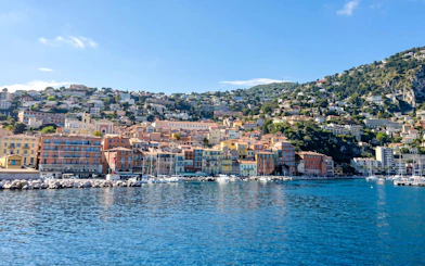 Villefranche-sur-Mer waterfront with colorful buildings and boats, view from the sea.