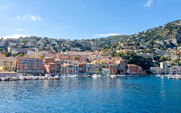 Villefranche-sur-Mer waterfront with colorful buildings and boats, view from the sea.