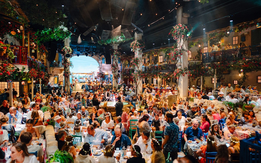 Guests dining at Mamma Mia! The Party with vibrant decor and lively atmosphere.