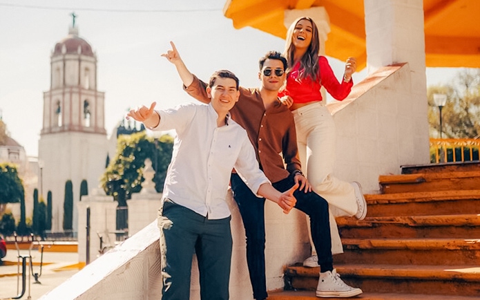 Guests enjoying Plaza de la Concordia in Cholula with a historic tower in the background.