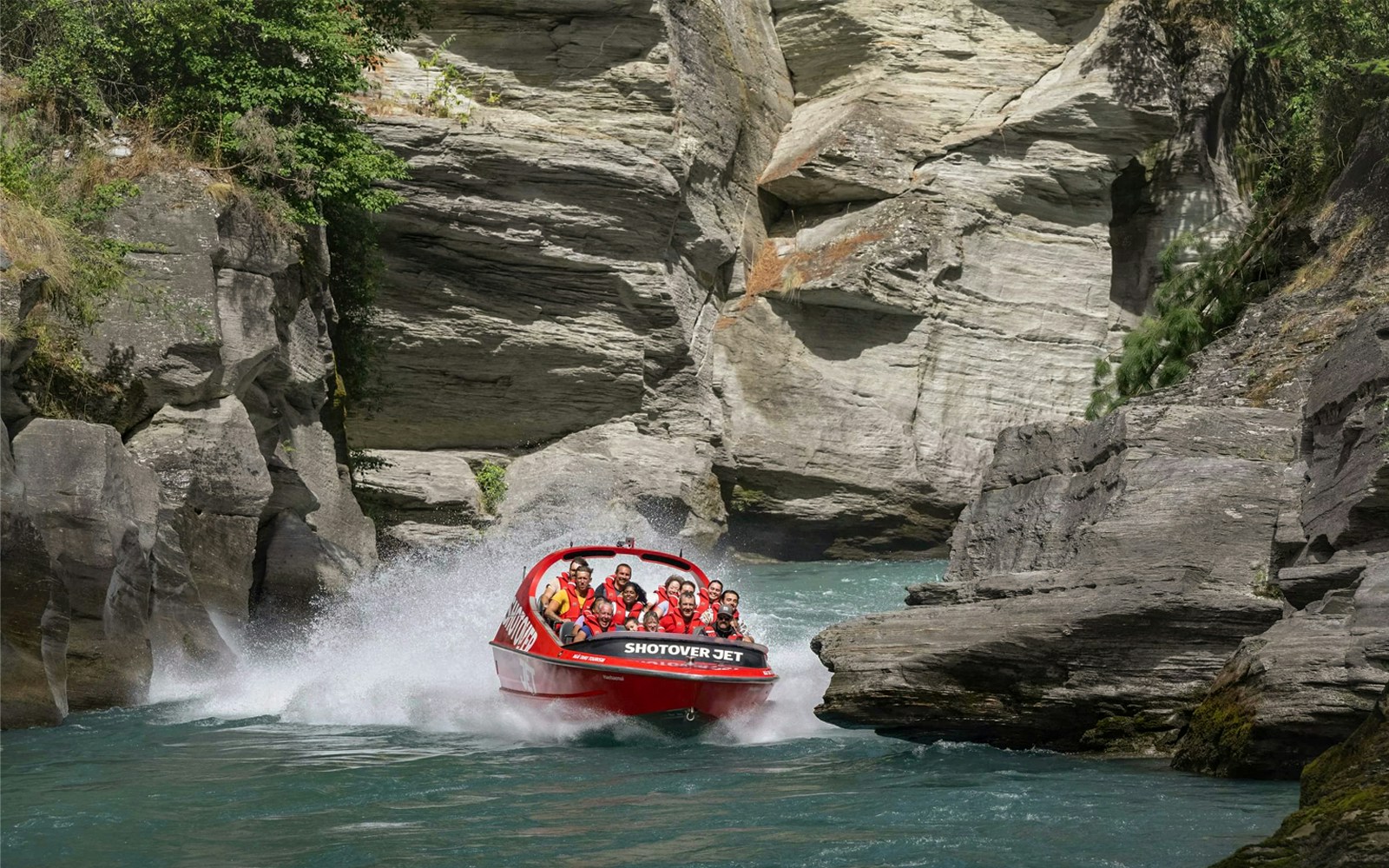 Shotover Jet navigating through narrow canyon in New Zealand.