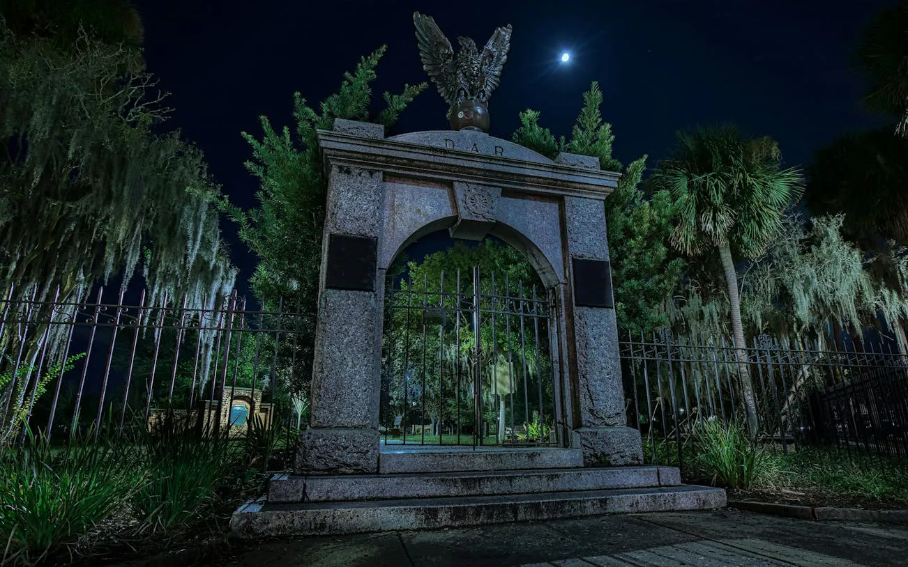 Historic cemetery gate under moonlight in Savannah, Georgia, for self-guided ghost exploration game.