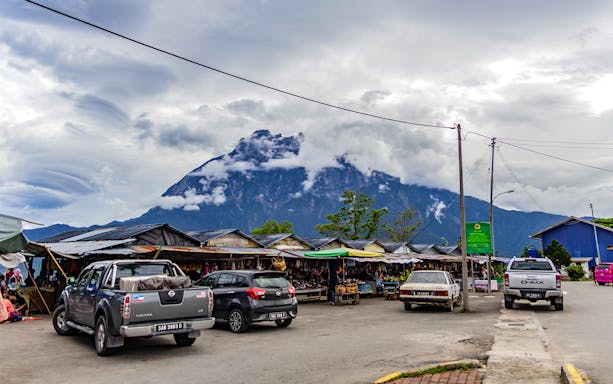 Market stalls with Mount Kinabalu in the background, part of the 4-in-1 guided day tour.