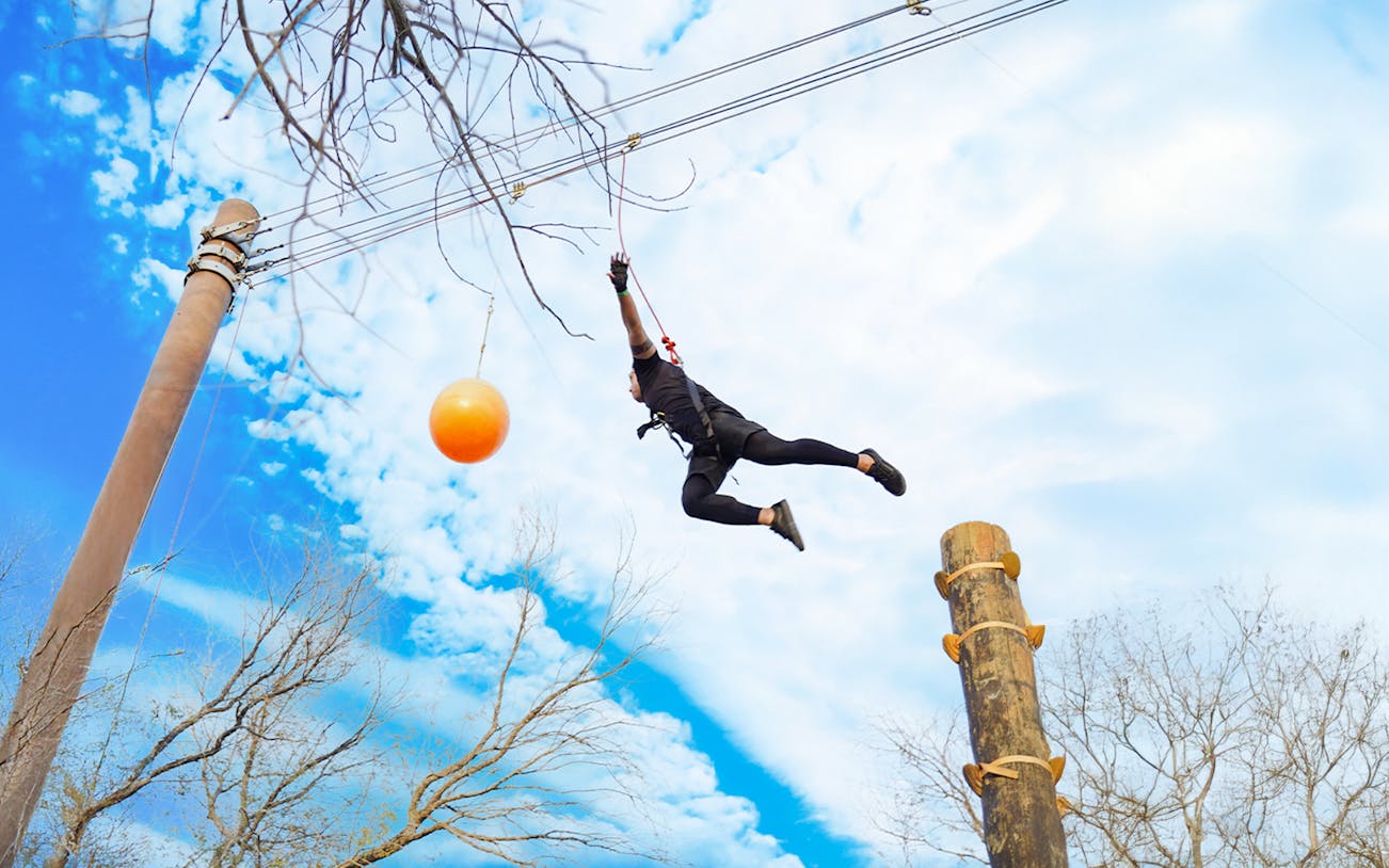 Man jumping with harness at Leap Of Faith activity, Aventura Parks.