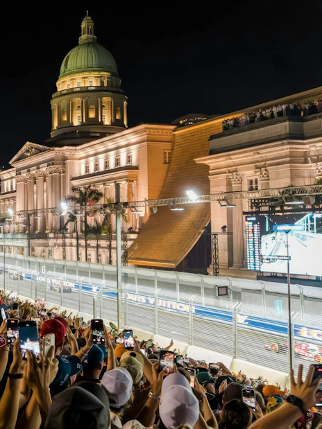 Crowd watching Formula 1 Singapore Grand Prix at Marina Bay Street Circuit with National Gallery Singapore in view.