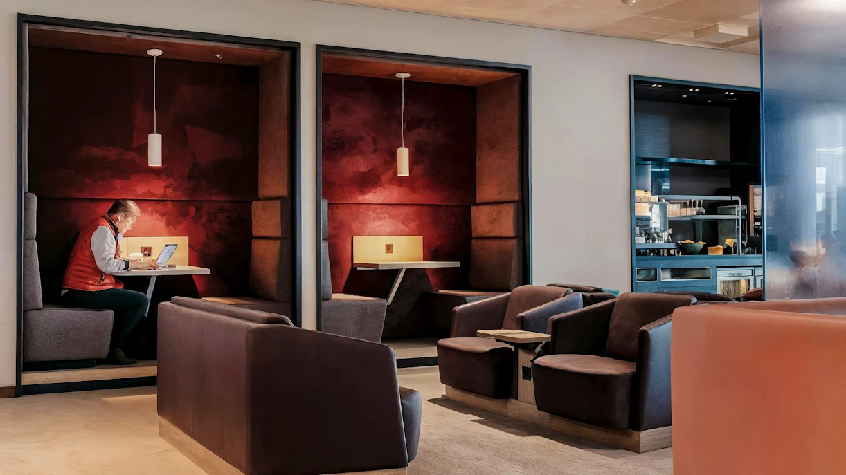 Aspire Lounge No.26 seating area with traveler using laptop, Schiphol Airport.