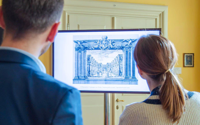 Visitors viewing an art display at Lobkowicz Palace Museum, Prague Castle.