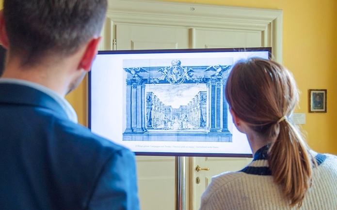 Visitors viewing an art display at Lobkowicz Palace Museum, Prague Castle.
