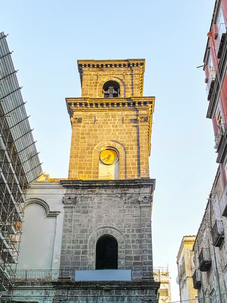 San Lorenzo Maggiore bell tower in Naples, Italy, surrounded by historic buildings.