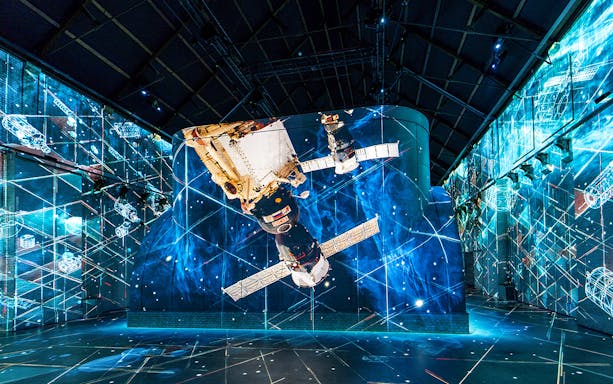Space-themed digital art projection at Fabrique des Lumières, featuring a spacecraft against a cosmic backdrop.