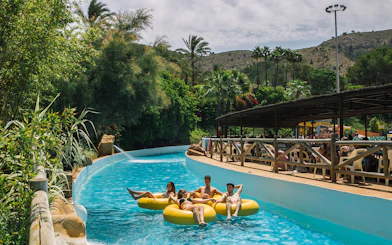 Family floating on yellow tubes in Aqualand Costa Adeje, Tenerife.
