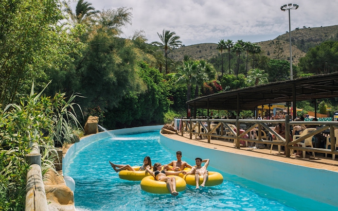 Family floating on yellow tubes in Aqualand Costa Adeje, Tenerife.