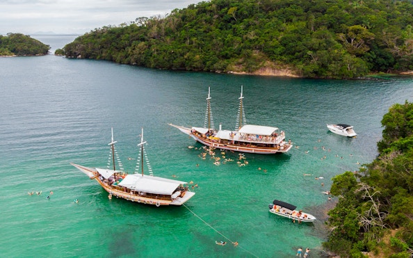 Boat tour with swimmers in clear waters of Ilha Grande, Brazil.