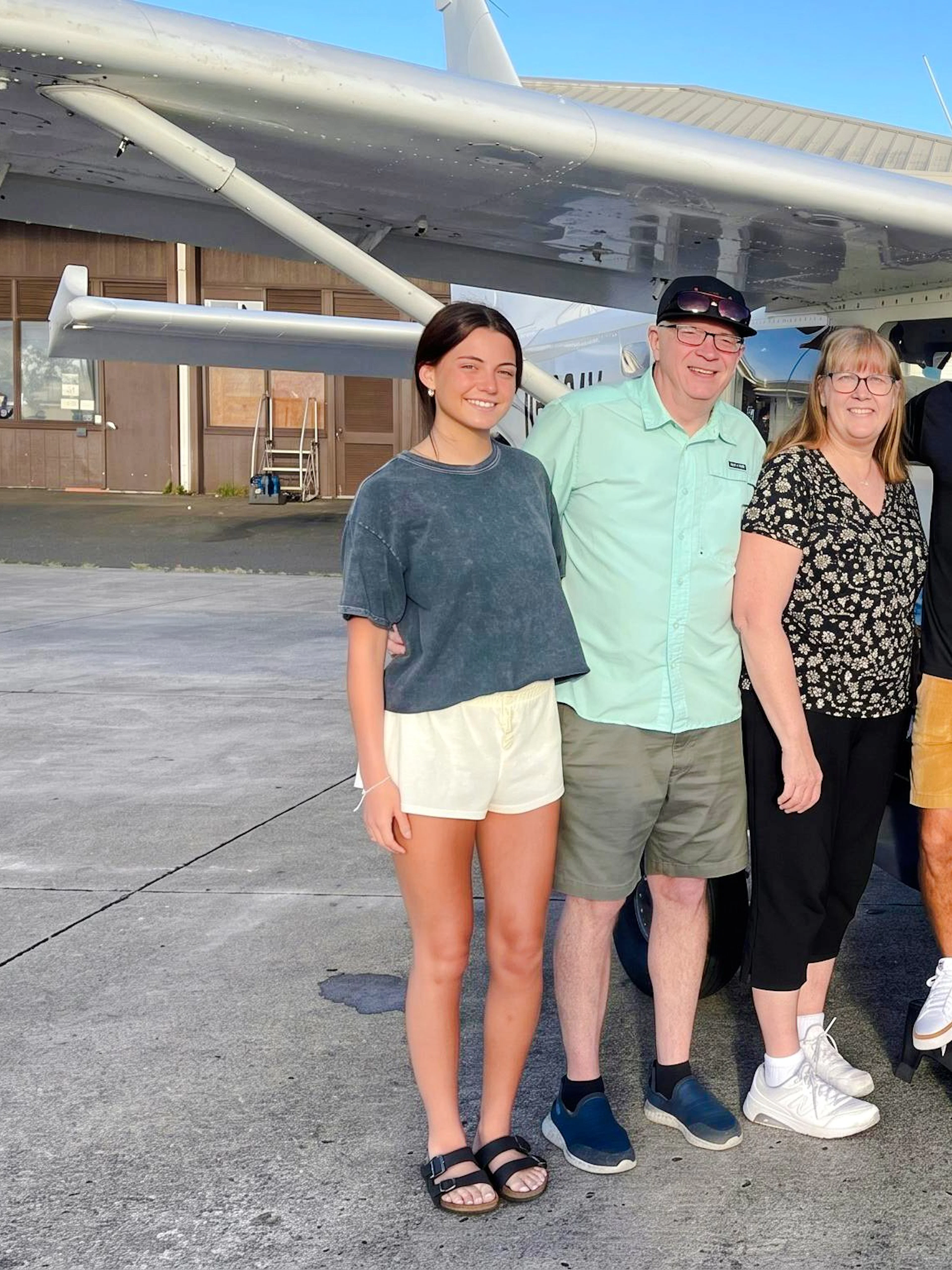 Group posing by small aircraft before Private Kauai Air Tour.