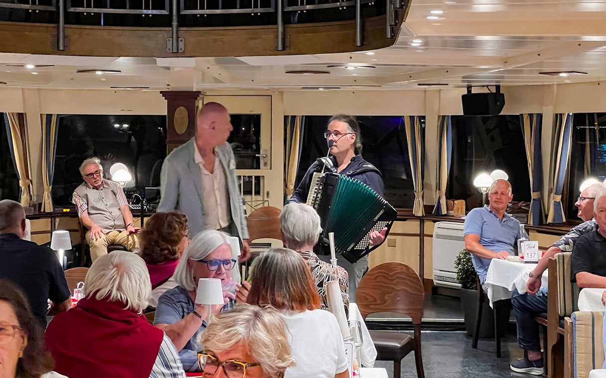 Accordion player performing for guests on Budapest Danube River dinner cruise.