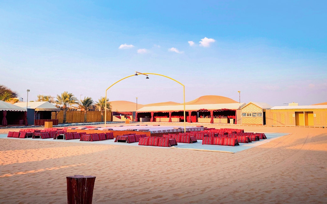 Desert camp setup for Abu Dhabi evening safari with seating and stage.