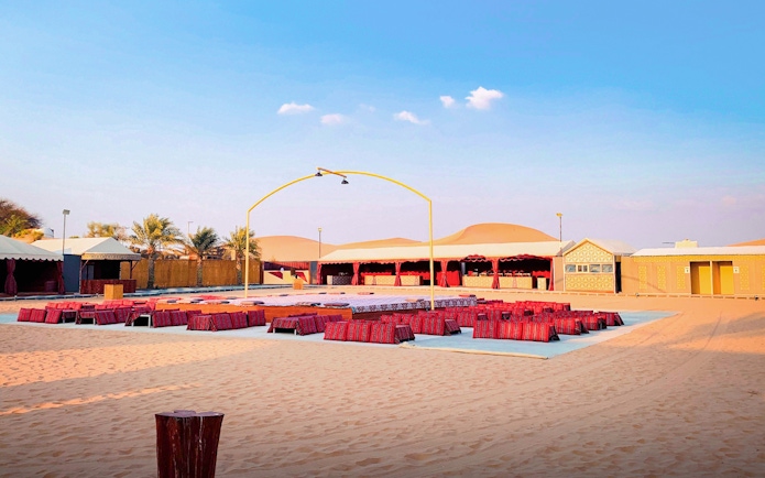 Desert camp setup for Abu Dhabi evening safari with seating and stage.