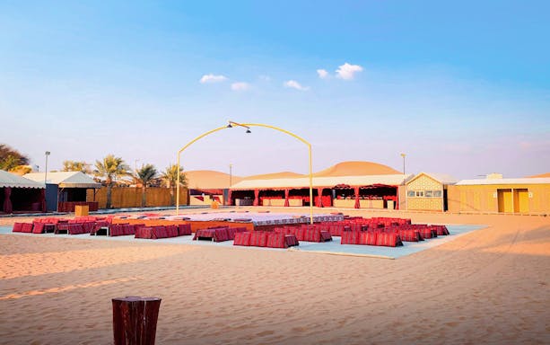 Desert camp setup for Abu Dhabi evening safari with seating and stage.