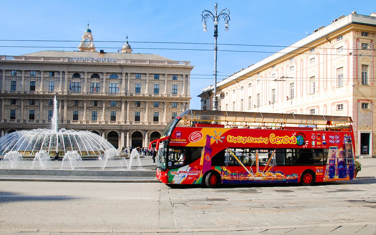 City Sightseeing bus in front of Piazza De Ferrari fountain, Genoa, Italy.