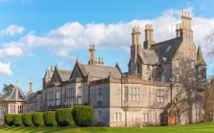 Historic mansion with ornate chimneys and manicured gardens, part of The Grande Ticket tour.