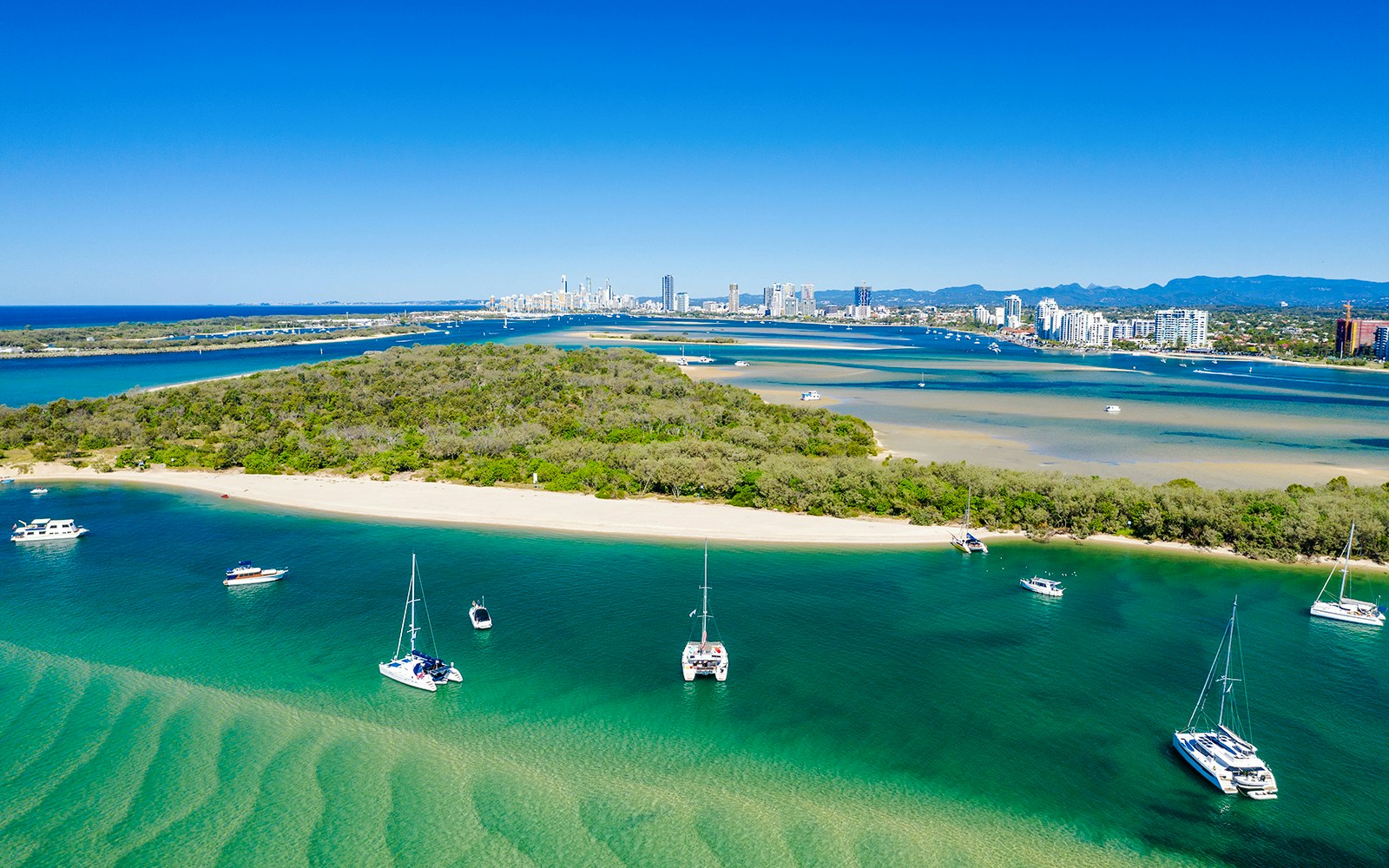 Boats anchored near Wavebreak Island, Gold Coast with city skyline in the background.