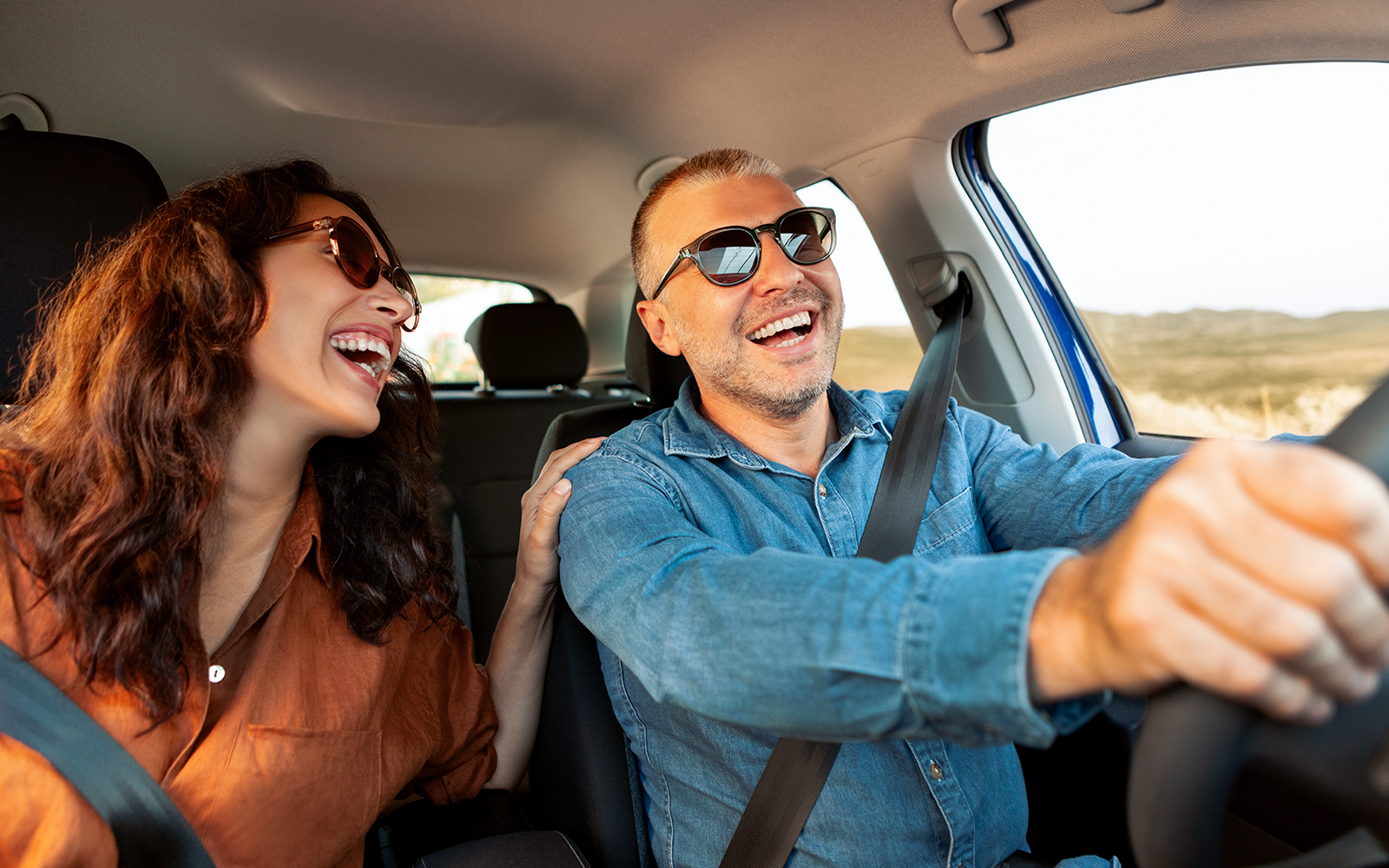 Couple driving a car on a scenic road trip from Rome to Naples.