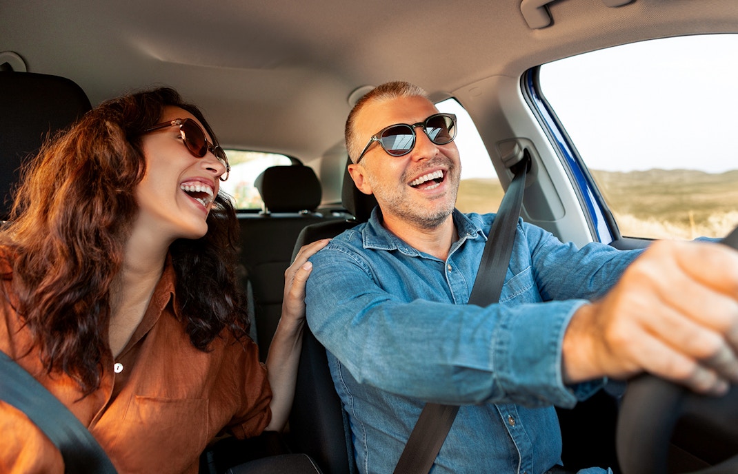 Couple driving a car on a scenic road trip from Rome to Naples.