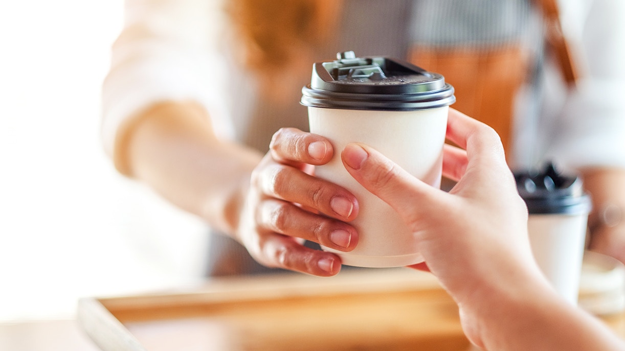 Takeaway coffee being handed over at Café Kitsuné Palais Royal.