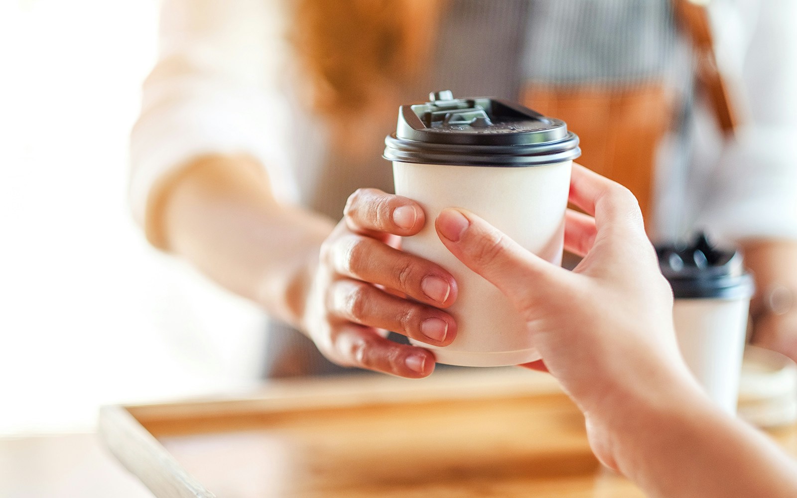 Takeaway coffee being handed over at Café Kitsuné Palais Royal.