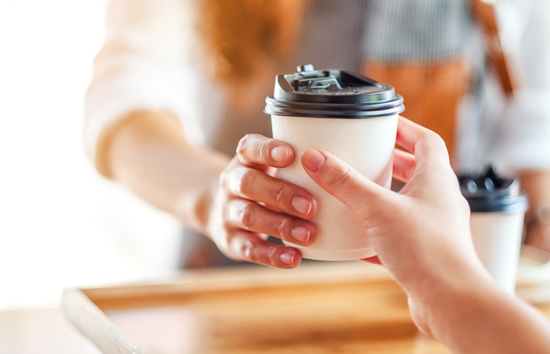 Takeaway coffee being handed over at Café Kitsuné Palais Royal.