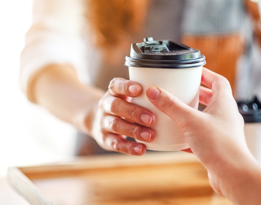 Takeaway coffee being handed over at Café Kitsuné Palais Royal.