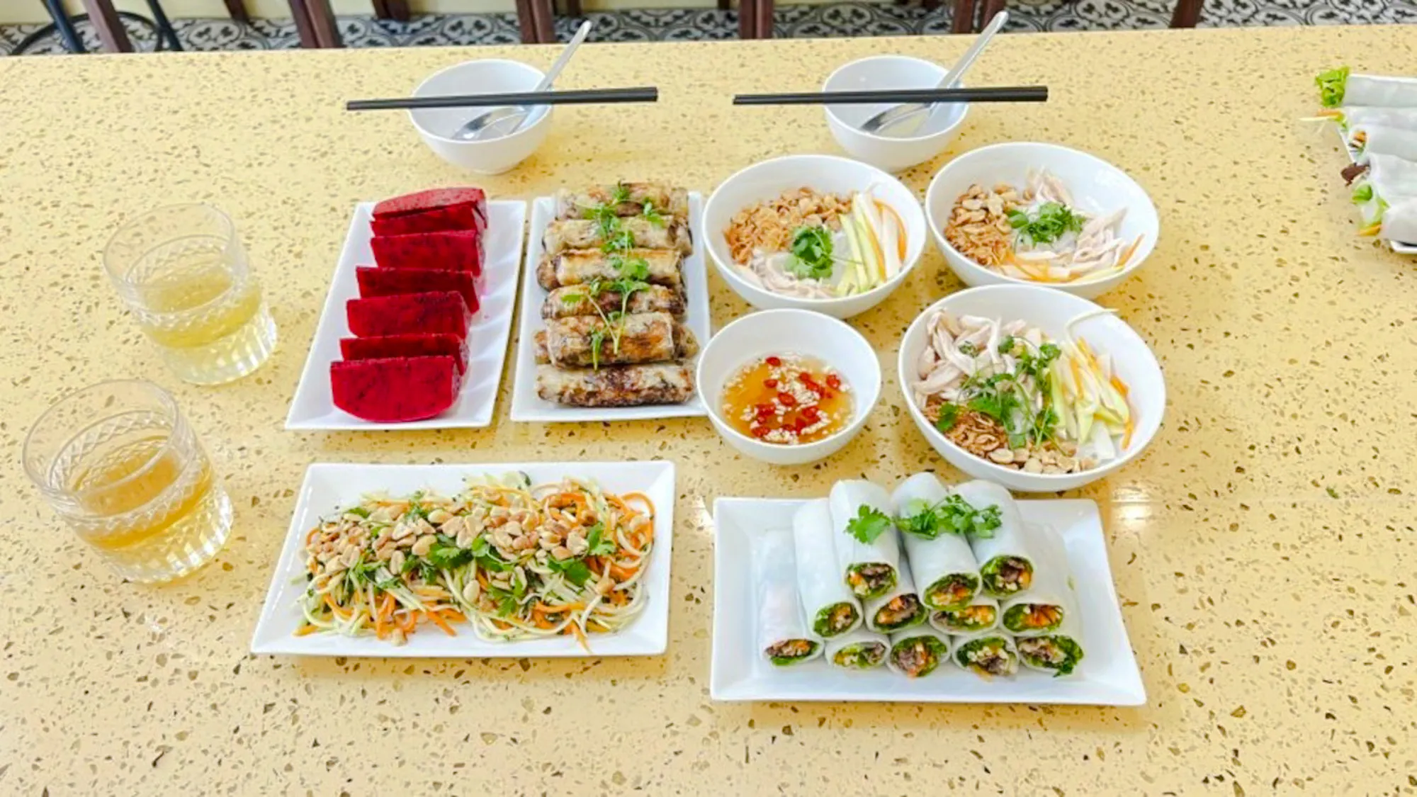 Vietnamese dishes including spring rolls and salads on a table during Hanoi market tour cooking class.