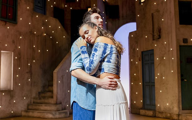 Couple embracing on stage during MAMMA MIA! El Musical performance.