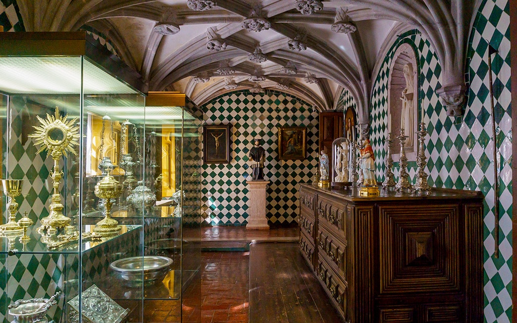 Sintra palace interior with religious artifacts and ornate ceiling.