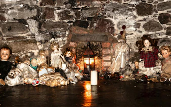 Creepy dolls and lantern in Edinburgh underground ghost tour setting.