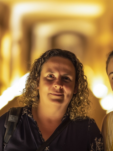Visitors exploring the illuminated corridors of the Roman Catacombs.