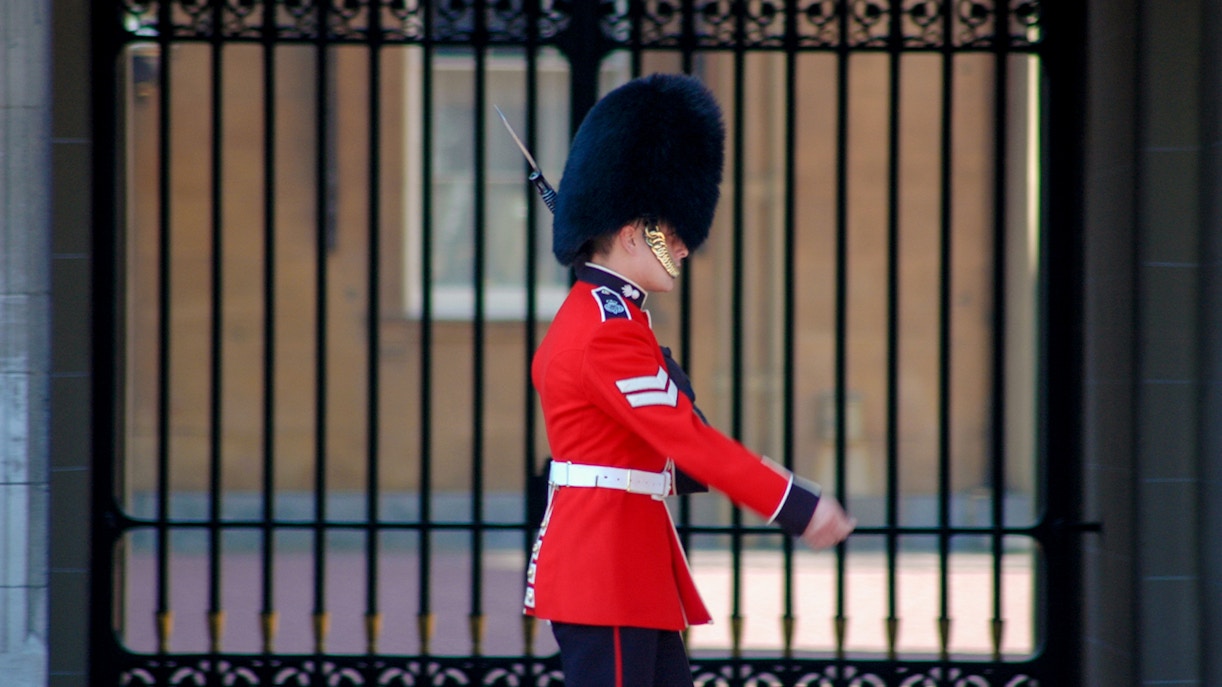 Buckingham Palace guard in red uniform and bearskin hat.