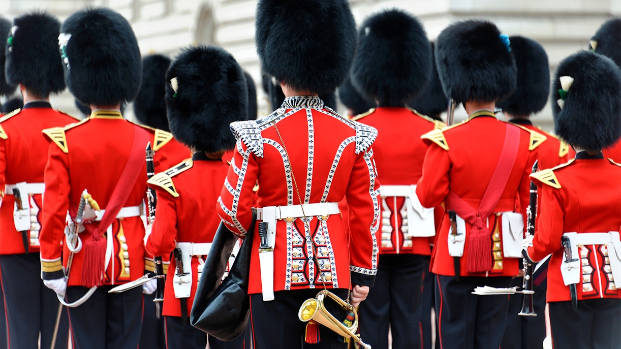 Buckingham Palace guards in red uniforms during Changing of the Guard ceremony.