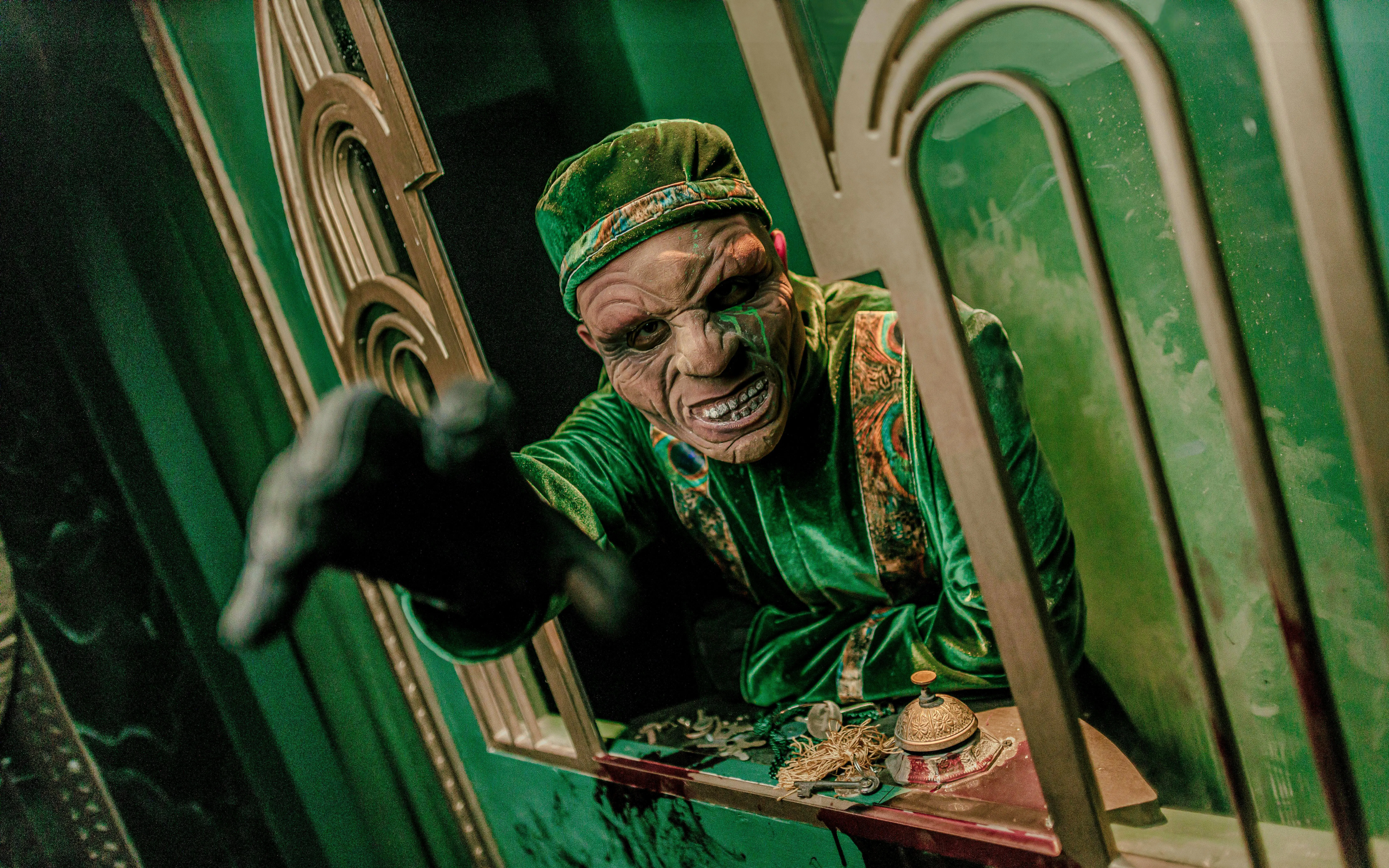 Actor in costume reaching out at Knott's Berry Scary Farm, Southern California.
