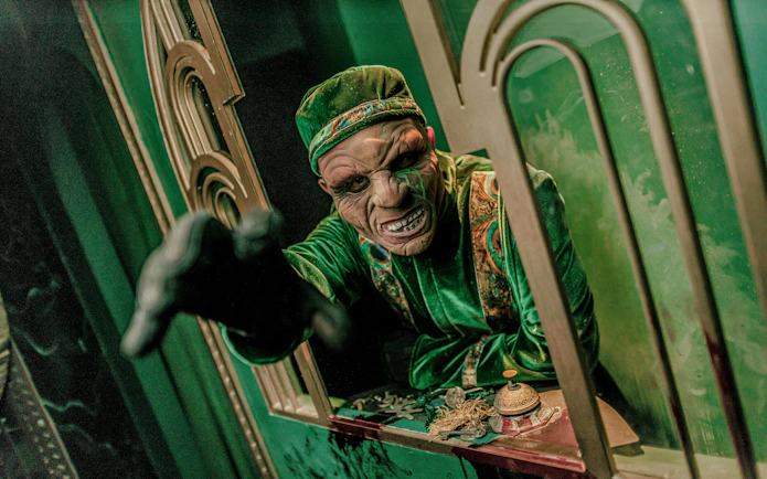 Actor in costume reaching out at Knott's Berry Scary Farm, Southern California.