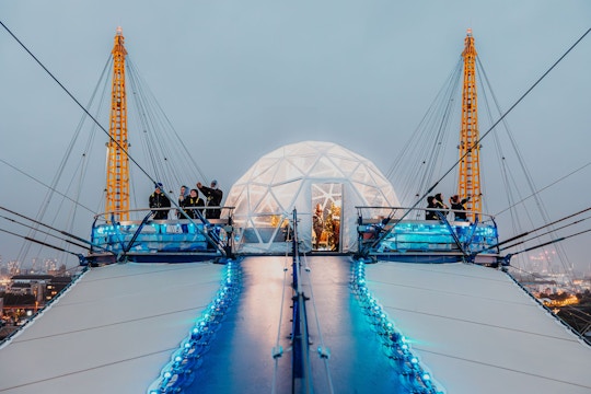 Visitors at the O2 dome summit with illuminated snow globe, London.
